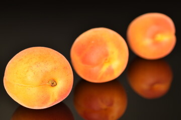 Ripe sweet, organic apricots, close-up, on a black background.