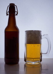 colored silhouette of a beer bottle with a cork and beer mug with beer poured into it on a black white background