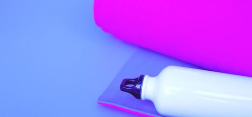 Bright purple yoga mat and bottle of water.