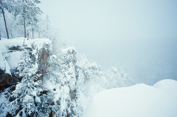 View from the top of the mountain in winter. Snow Blizzard. The cold landscape. Russia.