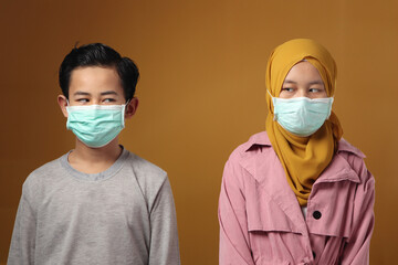 Boy and girl, brother and sister wearing medical mask to prevent covid coronavirus infection,...
