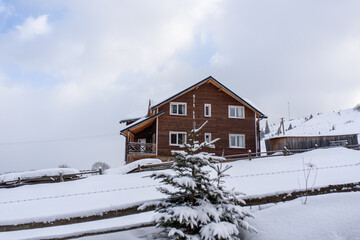 Fantastic winter landscape with wooden house in snowy mountains.