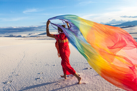 adult woman running with rainbow streamer, White Sands Nat'l Monument, NM
