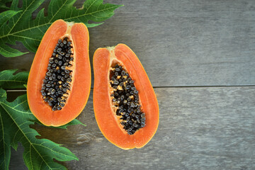 Half cut papaya placed on a wooden background.Papaya fruit on wooden background.close up papaya image. 