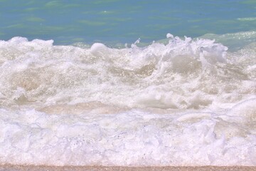 Wave of sea water crashing on the beach