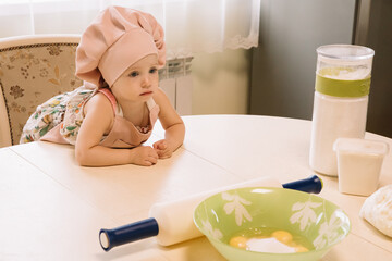 Little girl cooks at home in the kitchen