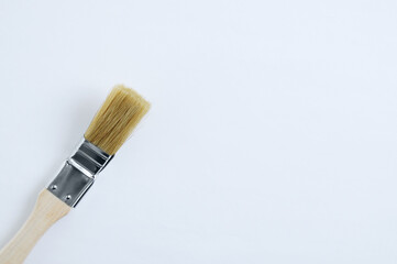 Brush for painting radiators with wooden handle on white background.