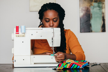 Woman sewing homemade face masks during pandemic with African cloth