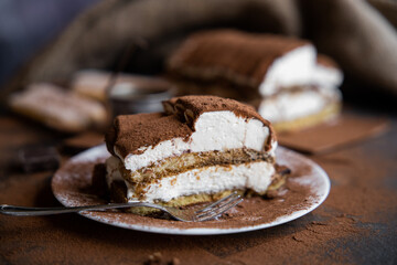 Tiramisu cake on a dark slate,stone or metal background. Selective focus