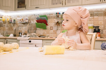 Little girl cooks at home in the kitchen