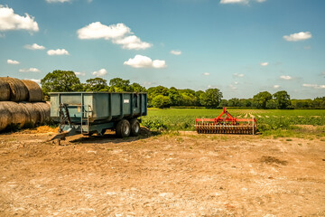 Tractor trailer and plough at the side of an arable crop field in the Norfolk countryside