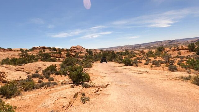 Desert Moab Utah off road following recreation ATV POV. Desert. Tourists visitors worldwide visit Arches and Canyonlands National Parks. Recreation, 4x4 red slick rock trail climbing exploring.
