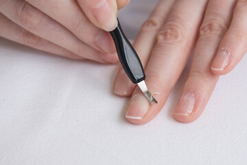 Home manicure. Self-treatment of nails during the pandemic and quarantine. Cuticle removal with a special tool. Close up.