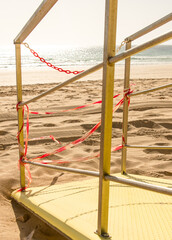 Yellow beach lifeguards's tower, empty and closed because of no tourism due to coronavirus crisis