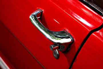 Vintage chromed handle of a red car with a lock. Vehicle. Driver's door. Photo in good quality. - Powered by Adobe