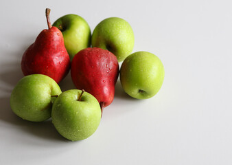 red pears and juicy green apples on a white background