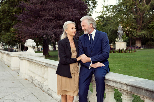 A couple arm in arm leaning on a balustrade in a park in Vienna.