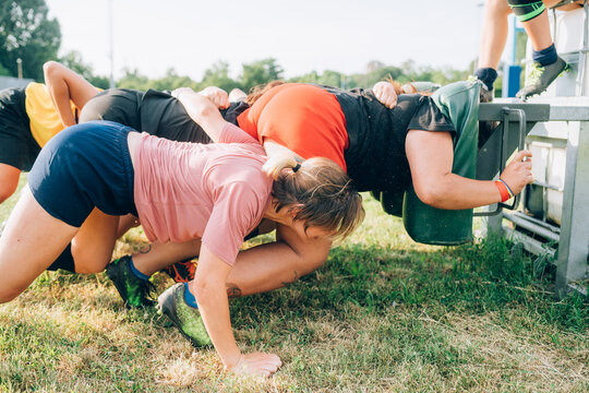 A group of women training to scrum against a machine on the training pitch.