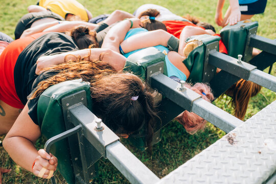 A group of women training to scrum against a machine on the training pitch.