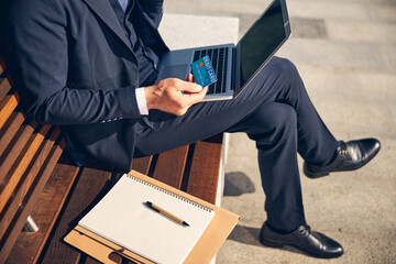 Man staying outside while working on laptop