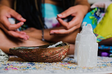 Woman burning sage to promote health, clarity and healing at home for relaxation
