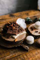 macaroni cookies and chocolate bars on a Board with nuts