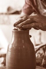 Potter hands making in clay on pottery wheel. Potter makes on the pottery wheel