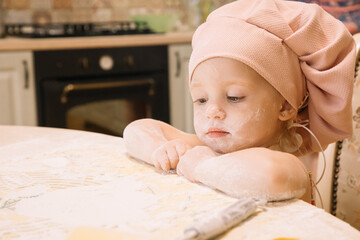 Little girl cooks at home in the kitchen