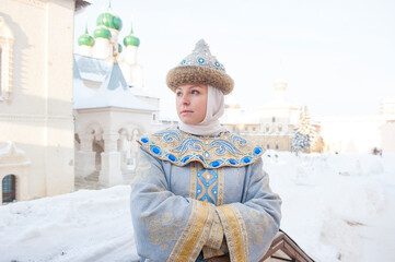a girl in old clothes on the background of the fortress walls
