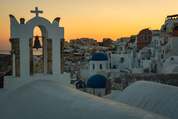 Sunset in Oia village on Santorini, Greece. Famous Santorini sunset capture.  Blue dome churches in the background. 

