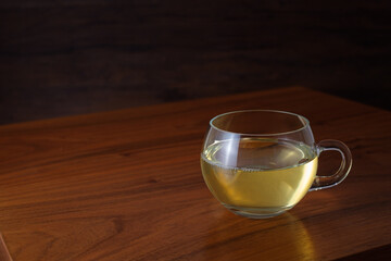 Glass cup of green tea on wooden table