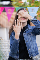 Beautiful woman with brunette hair in jeans clothes. Fashion mode showing ring and closed face by...