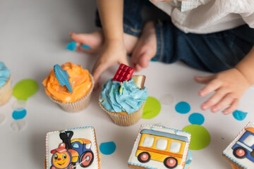 a child's hand reaches for the cupcakes. birthday cupcakes