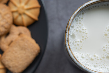 Milk cup and danish cookines in background. Close up view.