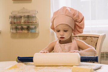 Little girl cooks at home in the kitchen