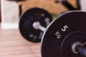 Obraz na płótnie Canvas Olympic gym bar with black weight disc on parquet floor