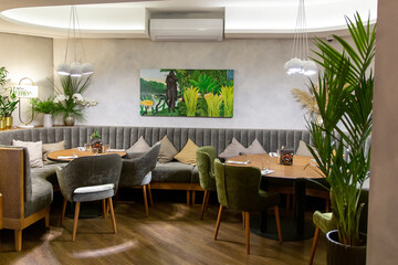 Interior of cozy modern restaurant with soft sofas and armchairs