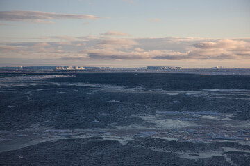 Antarctica landscape with ice and icebergs at sunset on a winter day