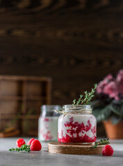 Raspberry smoothie, milkshake in a glass jar on a dark wooden background. Natural summer detox drink. Healthy eating concept.