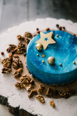 blue mousse cake on a wooden tray with nuts