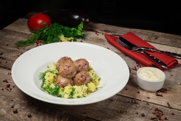 Homemade veal cutlets with mashed potatoes and fresh herbs. Served with tomato . On a beautiful wooden background