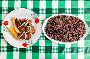 Traditional cuban recipes; fried pork chunks and black beans and rice, well known as 
