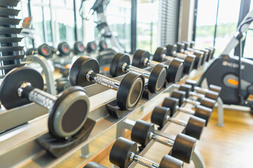 Fototapeta na wymiar Fitness club weight training equipment gym modern interior , Barbells of different weight on rack.