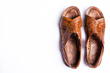 Pair of brown leather traditional Panamanian sandals on white background