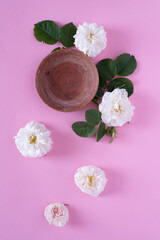 Obraz na płótnie Canvas Beautiful white garden roses on a pink background.