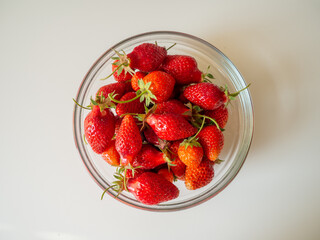 red strawberries on a table in a transparent plate