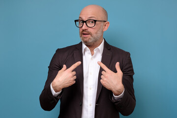 Handsome man looking disappointedly at camera pointing at himself with hands being surprised to be...