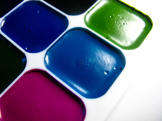new watercolor school paints in a plastic box on a white background