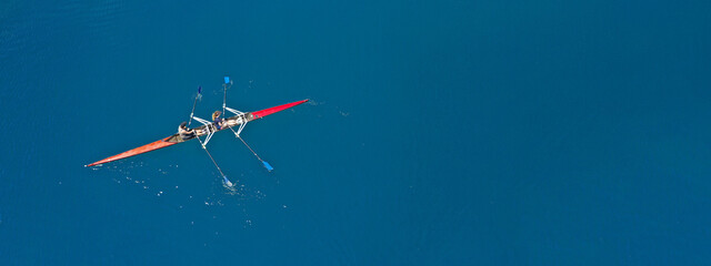 Fototapeta na wymiar Aerial drone top ultra wide panoramic view of sport canoe rowing synchronous female athletes competing in deep blue sea