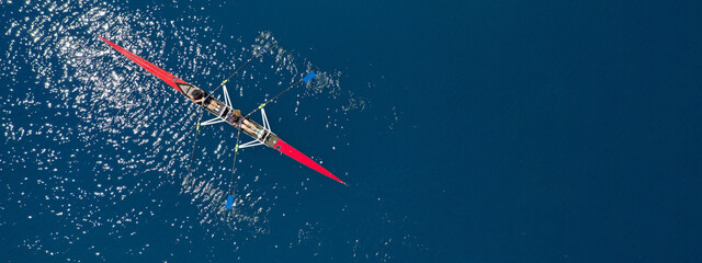Aerial drone top ultra wide panoramic view of sport canoe rowing synchronous female athletes competing in deep blue sea - obrazy, fototapety, plakaty